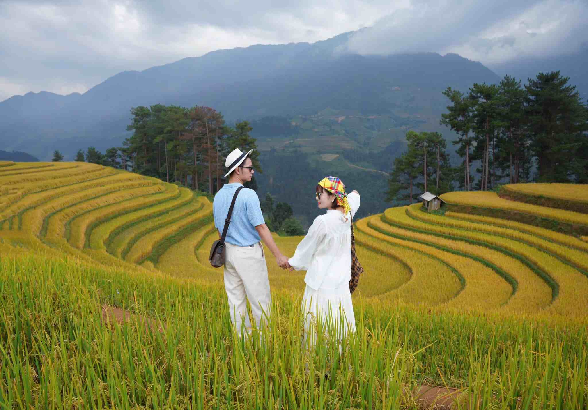 Hai du khách phối trang phục sáng màu giữa ruộng bậc thang