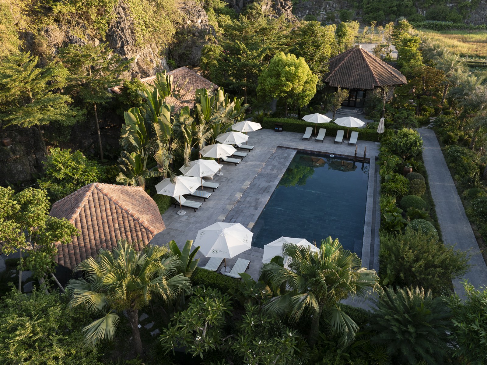 Toàn cảnh hồ bơi ngoài trời giữa cây xanh tại An Hideaway Resort Ninh Bình